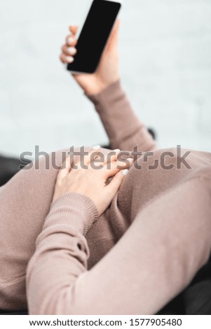 cropped view of pregnant woman having online consultation with doctor on smartphone