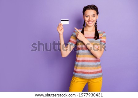 Photo of pretty lady holding credit card online shopping advising best way for lazy people direct finger wear casual t-shirt yellow pants isolated pastel purple color background