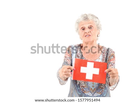 Pretty old woman holding a flag of Switzerland against a white background