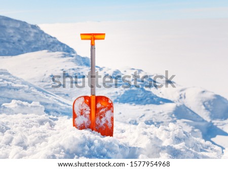 Shovel for  snow cleaning during snowfall or avalanche. Snow storm in winter time season. Tool for maintenance during drive away.