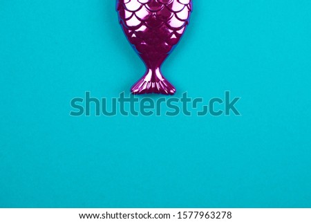 Pink mermaid tail on a turquoise background.