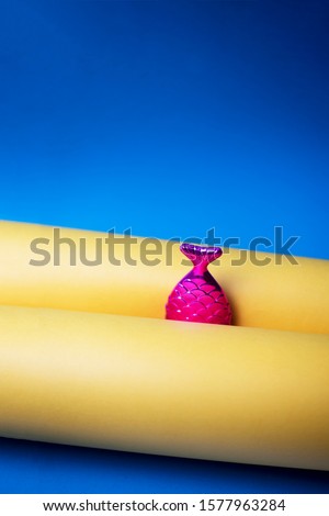 Burgundy fish tail on a yellow-blue background. 