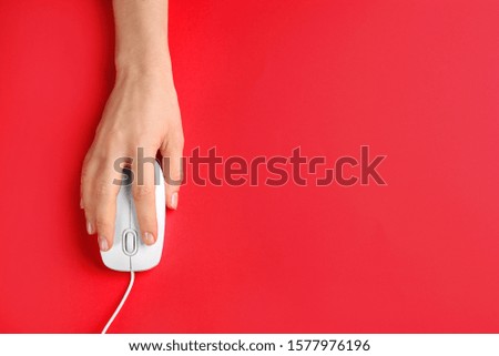 Woman using modern wired optical mouse on red background, top view. Space for text