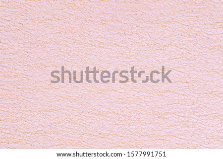 Rose gold organza cloth texture, copy space, text place. Metallic glitter golden fabric. Christmas yellow pink golden background. Festive metallic shimmers background in pastel color