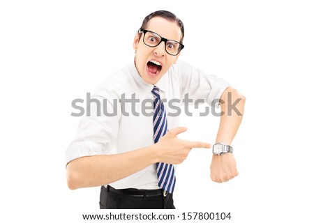 Angry man shouting and pointing on a wrist watch isolated against white background  Royalty-Free Stock Photo #157800104