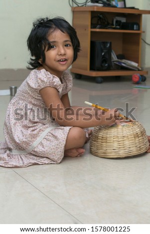 Cute little girl painting on bamboo casket. Indian little girl making painting. Creative child artist