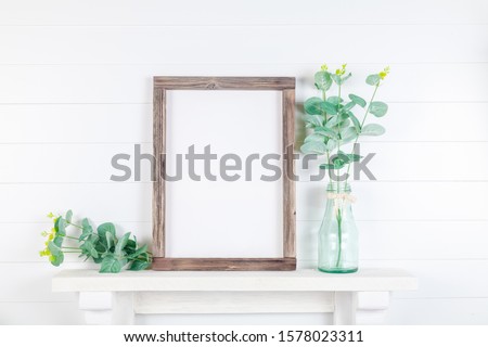 Spring or summer wooden frame mockup with greenery on a light background