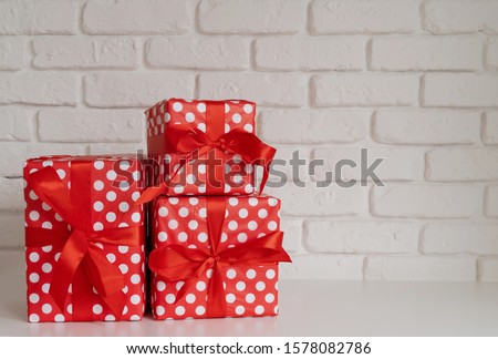 Bright red pile of gift boxes on white wall background