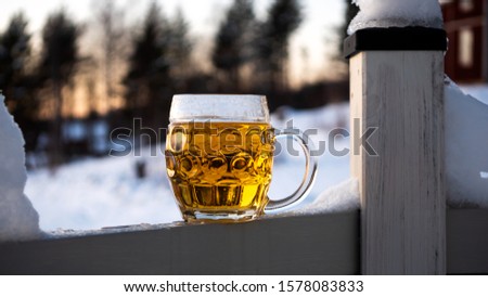 Close up of full pint of beer. Set in a cold winter sunset background.
