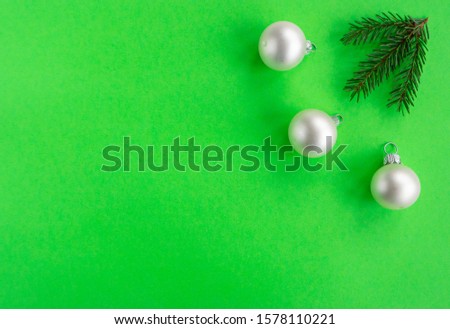 Christmas New year flat lay with pine tree, silver ball and branch on light green background. Greeting card, top view, copy space. 