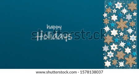 Christmas banner with star shaped ginger cookies and "happy Holidays" wishes written with sugar sprinkles