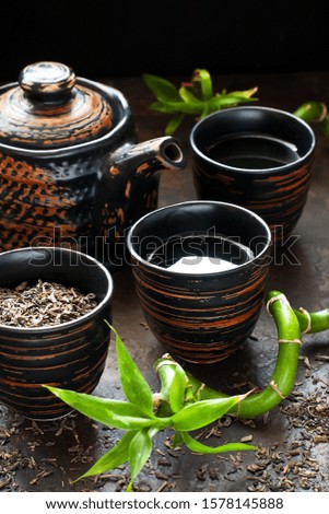 Asian style background - teapot  and   cups on dark  concrete background, selective focus with shallow depth of field