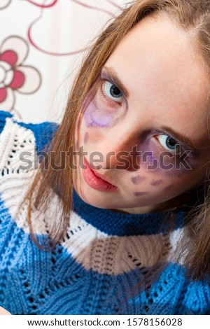 The girl painted her face, talking about dissatisfaction and sadness.