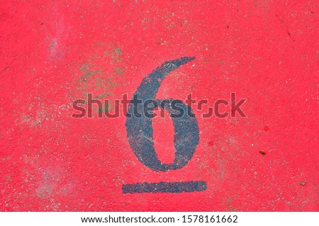 A house number plaque, showing the number six (6)