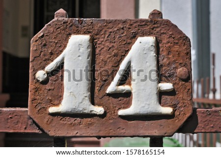 
A house number plaque, showing the number fourteen (14)