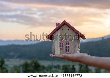 Hands holding house, Real estate investment is a business to build a house to sell to buyers in the market through agents. estate service concep