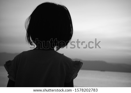 black and white image of back of a running child