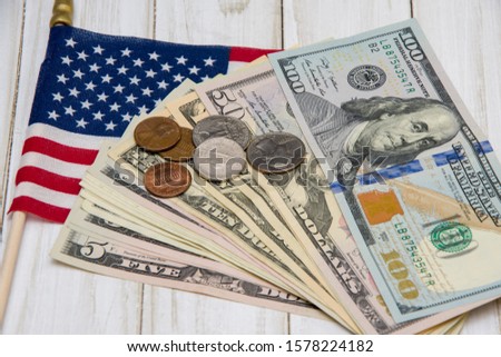 Against the background of the American flag, coins and dollar bills are army identification medallions. Concept: military pension, salary in the army, insurance for soldiers, mercenaries and contracto Royalty-Free Stock Photo #1578224182