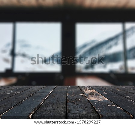 Christmas and New year background with empty dark wooden deck table over christmas tree and blurred light bokeh. Empty display for product montage. Rustic vintage Xmas background.
