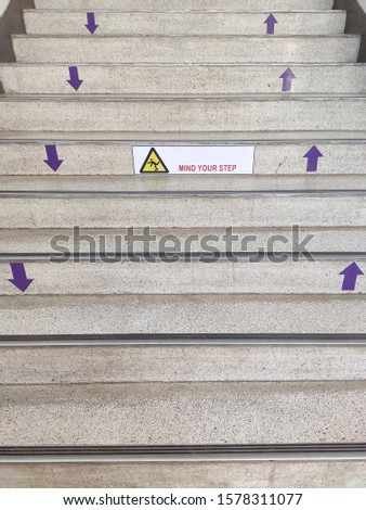 Stairs up and down to make cement with signs to be careful of slippery