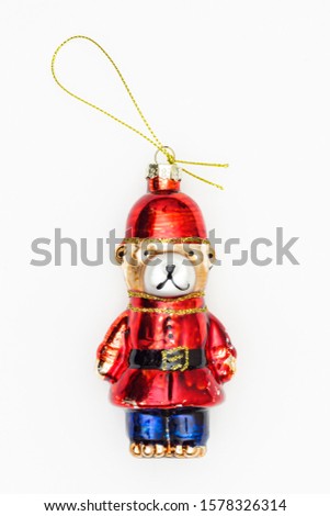 Glass bear in red and blue police uniform, colorful toy for Christmas tree decoration, isolated on white background. New year's toys on the suspension.  Shining a cartoon bear with a rope for hanging.