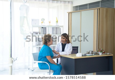 Female doctor checking senior patients heartbeat using stethoscope in the hospital