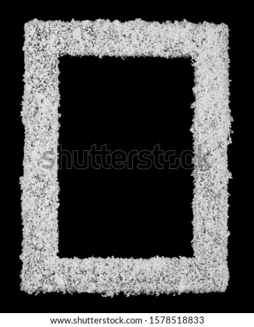 Photo frame in white fluffy snow isolated on a black background close-up. As a background for Christmas and New Year illustrations.