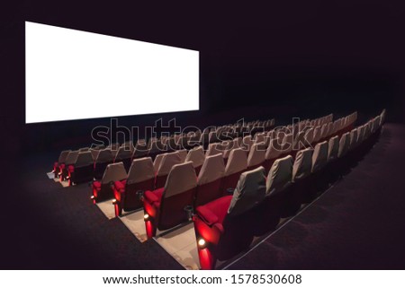 Empty movie screen with blurry of chair in the movie theater.