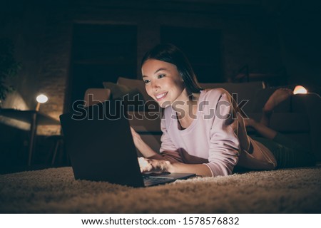 Profile photo of domestic lady looking notebook texting best foreign friend have to wait timezone difference lying floor near sofa casual clothes dark living room indoors Royalty-Free Stock Photo #1578576832