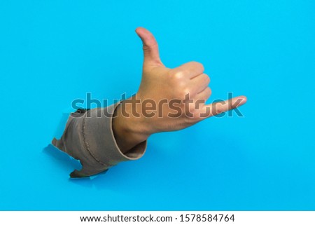 Man hand in shaka or calling gesture on a blue background