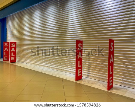 Red colored sale off banner at closing shopping outlet 
