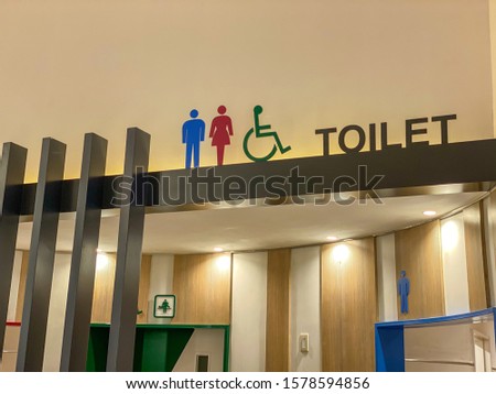 Public toilet signs in different color in shopping mall