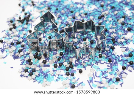 blue black turquoise silver star shaped sugar sprinkles with metal biscuit cutter in advent season christmas tree star shape to cookie baking or as realistic christmas decoration on bright background