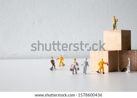 miniature people laying wooden blocks in a square shape Put on the white table, Concept: idea business teamwork planning, People are preparing to celebrate their success