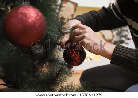 Man hands decorates a Christmas tree for New Year. Last preparation for Christmas