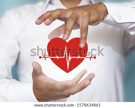 The concept of health security, everyday life, health. Insurance is associated with the image of a heart under the protection of hands. Royalty-Free Stock Photo #1578634861