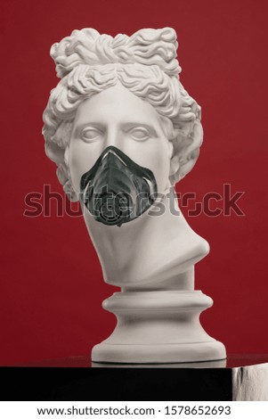 White plaster statue of a bust of Apollo Belvedere in a mask respirator covering his face on colorful backgrounds