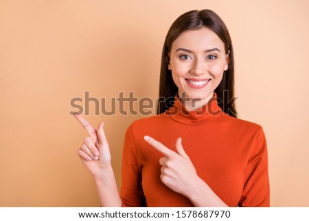 Photo of cheerful charming nice cute beautiful lawyer lady pointing at emptiness adverting something isolated over beige pastel color background