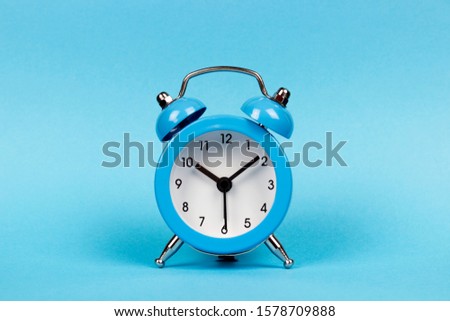 blue alarm clock on a blue background, copy spaсe	