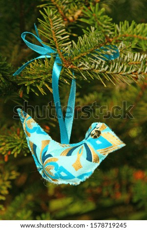 Blue hand made bird hanging on Christmas tree