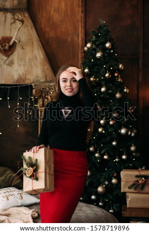 Charming girl holding a Christmas gift in her hands. Studio photo with Christmas mood. copy space.