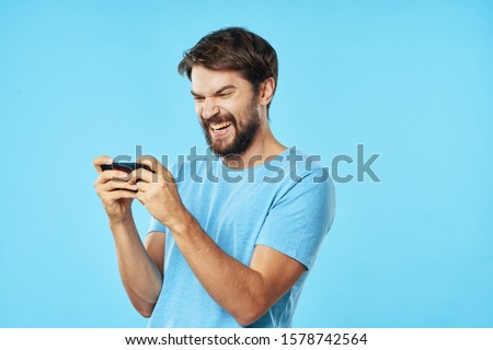 Handsome man in blue t-shirt mobile phone emotions success