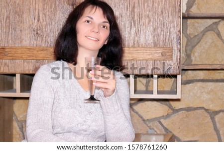 woman stands by the fireplace