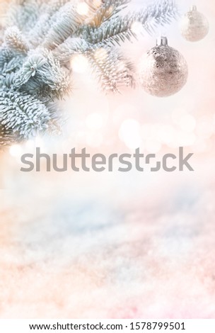 Christmas and advent background. Silver balls on fir branches in front of winter landscape. Festive snowy backdrop with golden bokeh for christmas holidays.Concept for design, banner and place 