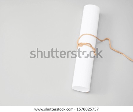 white paper rolls with packthread isolated on gray background, paper Blank portrait A4. brochure magazine. 