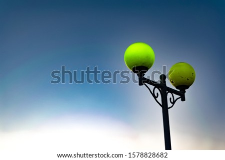 Bright and colorful lights on the waterfront at dusk and night, seascape, green and yellow light, blue starry sky. Russia, the village of Divnomorskoye. Round, glowing balls.