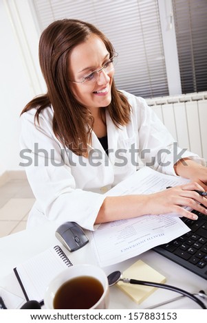 Close-up of a female doctor smiling and working in office