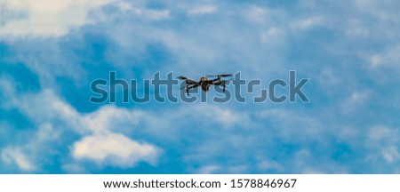 Long distant shot depicting one drone flying over clean sky background