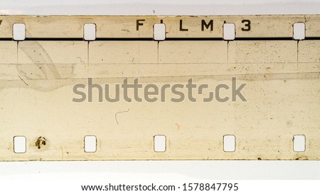 detail macro shot of blank exposed grungy 16mm filmstrip on white background