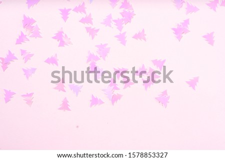 Christmas flat lay scene with pink fir tree confetti boder, top view over pink